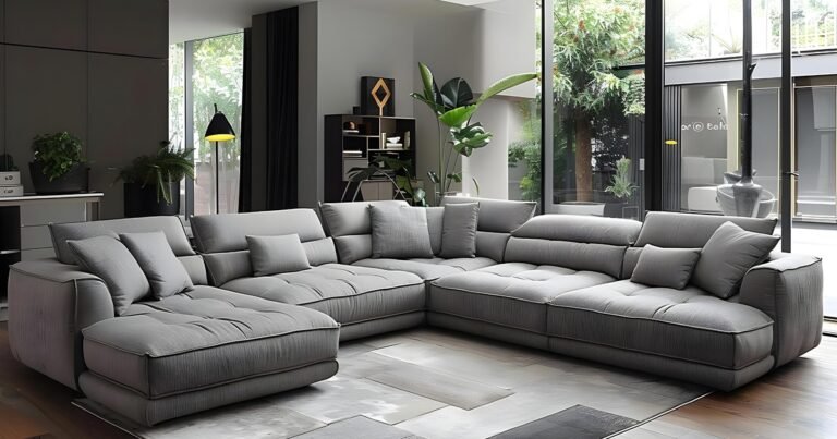 A modern living room featuring a large grey sectional couch with stylish decor and complementary colors.